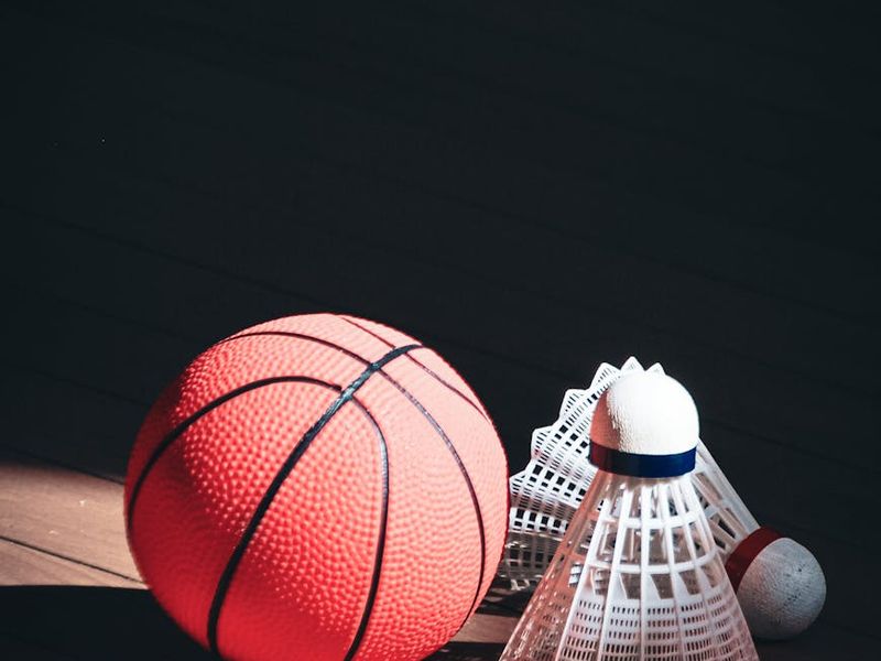 Close up of sports equipment and sneakers on wooden floor